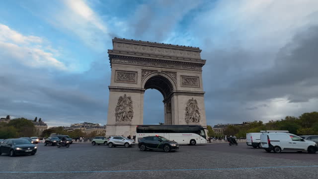 Traffic of cars passing against the backdrop of the Arc de Triomphe in Paris, France