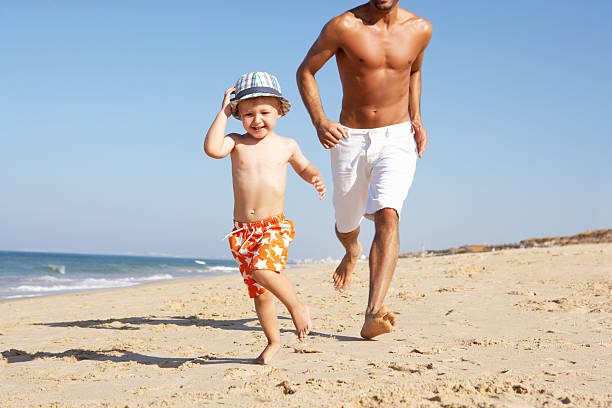 istock Father And Son Running Along Beach 177715767