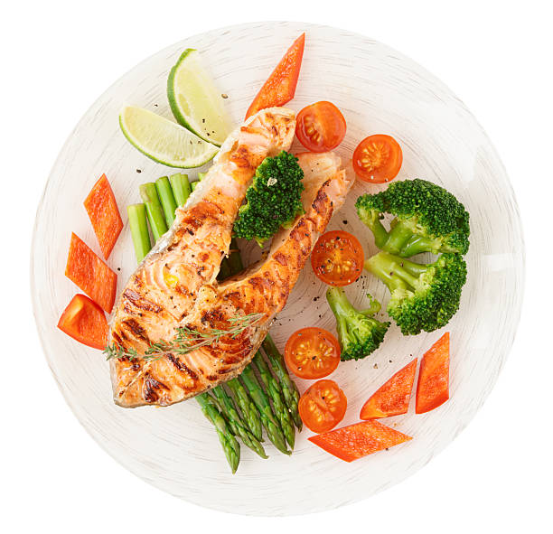 istock Salmon steak with vegetables isolated on white 177715854