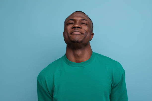 istock 30 year old handsome american man dressed in a basic t-shirt shy closing his eyes 1777164210