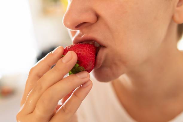 istock young woman bites a strawberry at breakfast. diet concept 1777164792