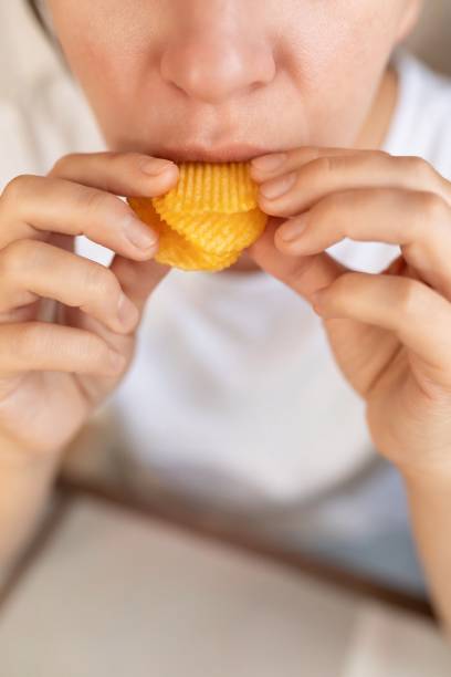istock woman eating potato chips for snack 1777165979