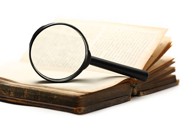 istock Magnifying glass and old book on the white background 177716682