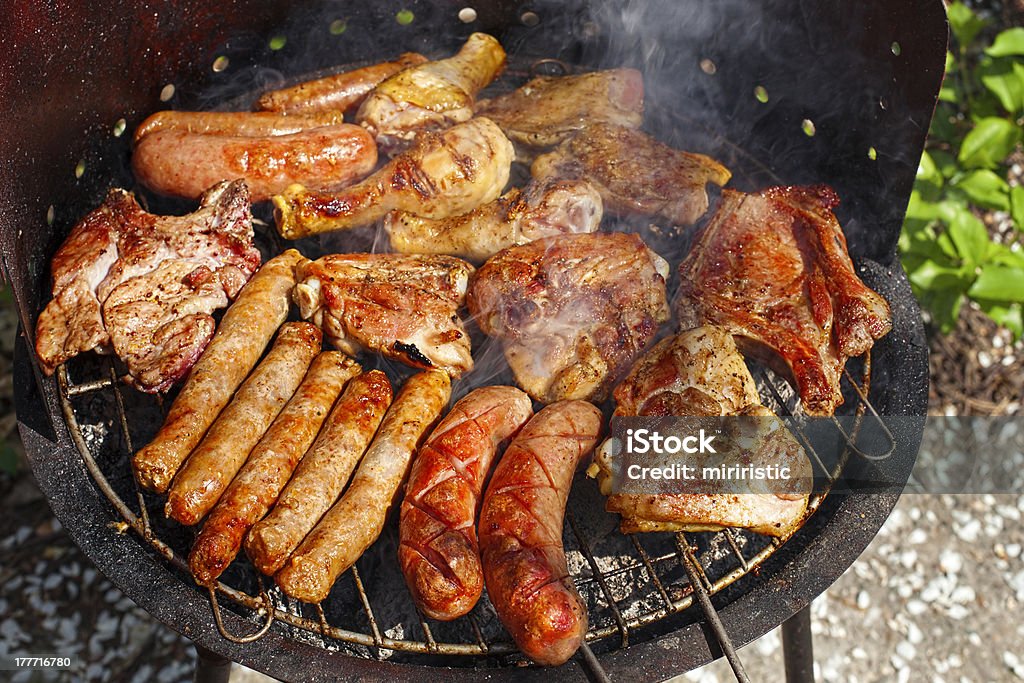 meat on barbecue variety of meat on an outdoor, sunlit, smoking barbecue grill American Culture Stock Photo