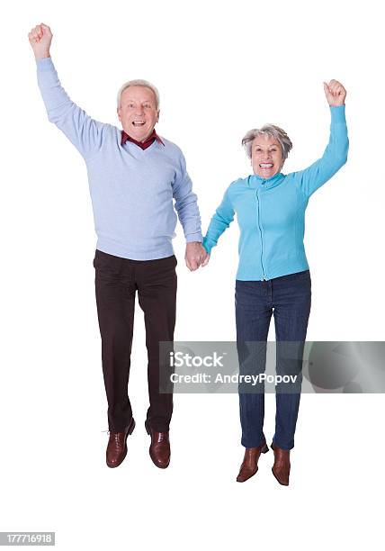 Portrait Of Senior Couple Jumping In Joy Stock Photo - Download Image Now - Jumping, Men, Friendship