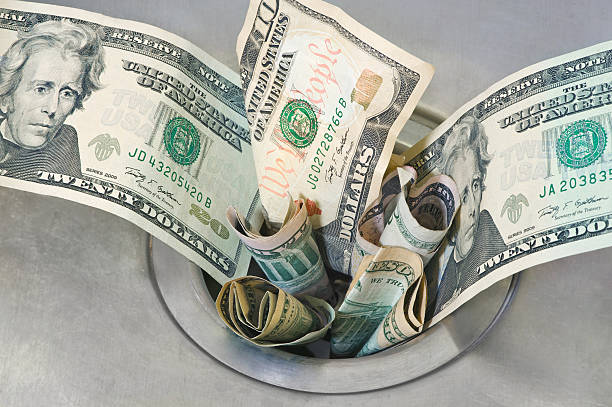 Money down the Drain Money down the Drain. Cash dollars slipping down a drain. loss stock pictures, royalty-free photos & images