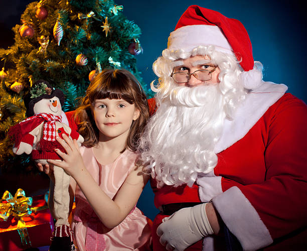 Santa Claus holding  bag and little girl -  toy stock photo