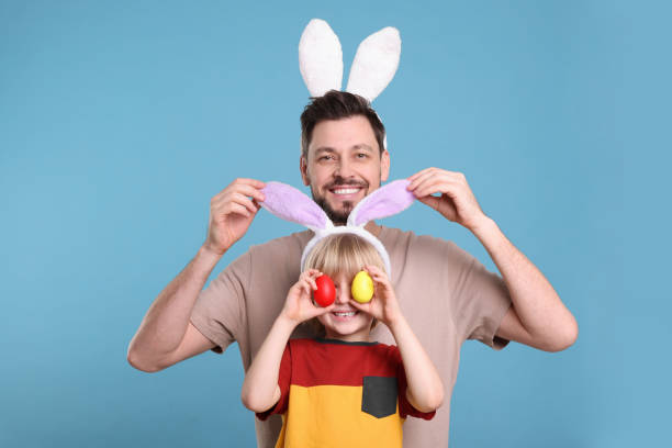 istock Father and son in bunny ears headbands having fun on turquoise background. Easter celebration 1777212269