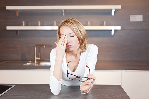 mujer en cocina - angestrengt fotografías e imágenes de stock