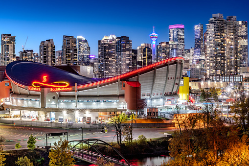 Calgary, Alberta, Canada, October 7, 2023: Calgary's downtown at night with the Scotiabank Saddledome in the foreground. The dome is home to the Calgary Flames NHL club.