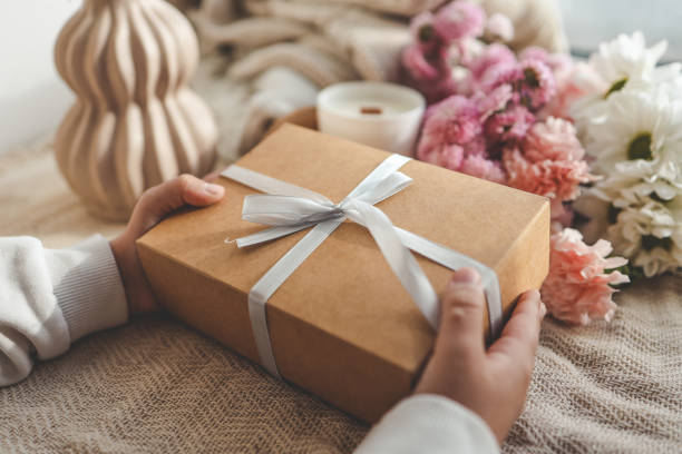 istock Gift box in hands with flowers at home 1777254613