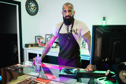 Portrait of a tattoo artist working at his studio.