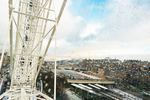 Rainy weather doesn't keep  tourists away from visiting the Edinburgh Christmas Market and riding the ferris wheel on a chilly day, Edinburgh, Scotland, UK
