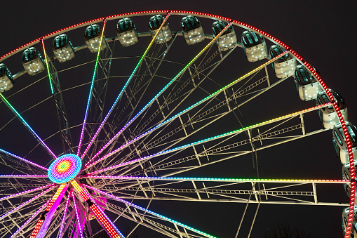 Partial view of the colorful ferris wheel at the George Square Christmas Market at night, Glasgow, Scotland, UK