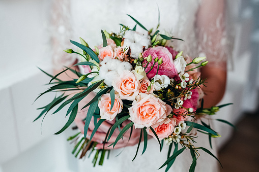 Beautiful wedding bouquet of the bride with delicate pink roses close up