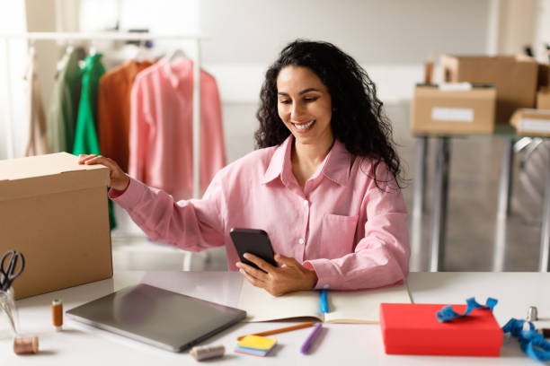 istock Lady Texting On Smartphone Packing Boxes In Clothing Showroom Store 1777264854