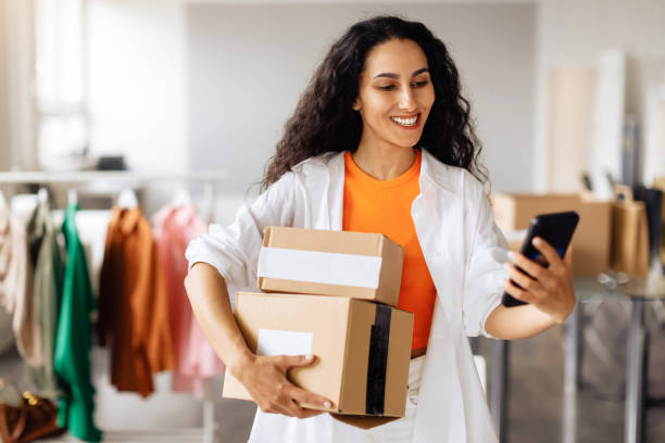 istock Fashion Designer Messaging On Cellphone Posing With Boxes In Store 1777266086