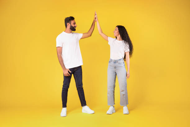 istock Arabic Couple Giving High Five Standing Over Yellow Studio Background 1777267248