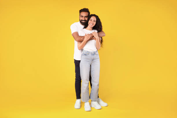 istock Beautiful middle eastern couple posing embracing on yellow studio background 1777267250