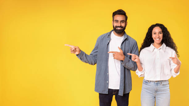 istock Arab couple pointing fingers aside showing copy space in studio 1777267268