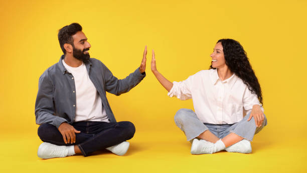 istock Middle Eastern Spouses Giving High Five Sitting On Yellow Background 1777267271