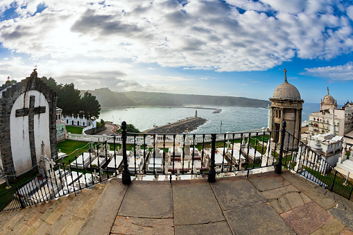 Travel image with historical fort along the coastline at the seaport of San Juan in Puerto Rico. White clouds against blue sky, blue sea and old castle.