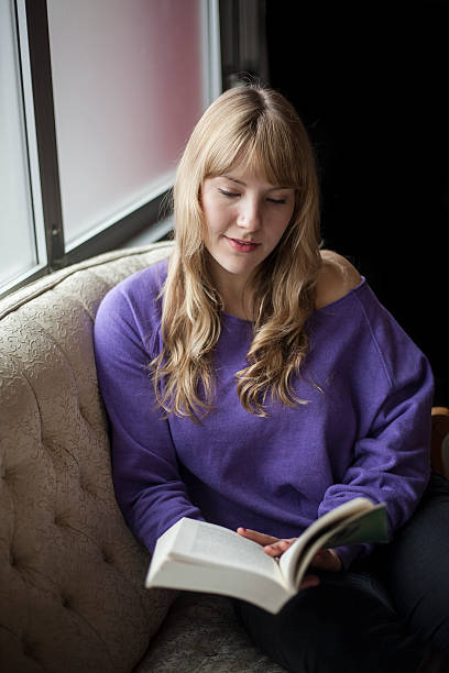 istock Young Woman with Beautiful Blue Eyes Reading a Book 177727128