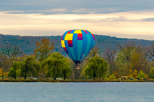 Ithaca NY USA November 4, 2023: Beautiful Hot Air Balloon preparing to land in Stewart Park at Cayuga Lake on a Saturday evening.