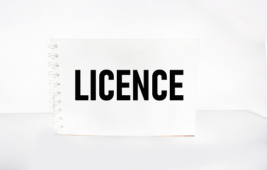 LICENSED word written on a notepad and white background