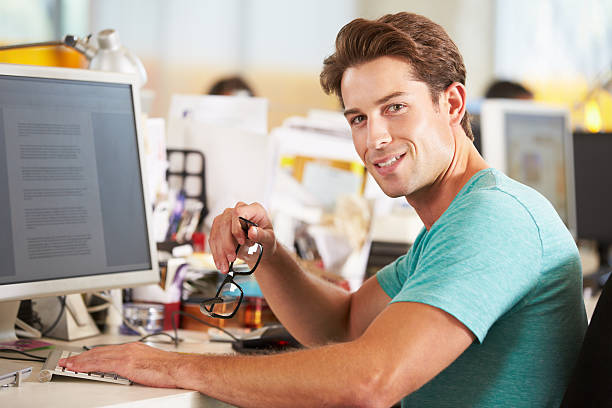 istock Man Working At Desk In Busy Creative Office 177727290