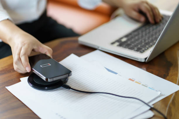 istock Charging mobile phone battery with wireless charging device in the table. Smartphone charging on a charging pad. Mobile phone near wireless charger Modern lifestyle technology concept 1777274577