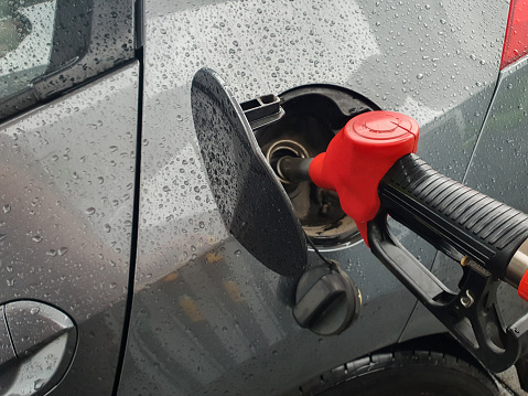 refueling Car fill with petrol gasoline at gas station and petrol pump filling fuel nozzle in fuel tank of car