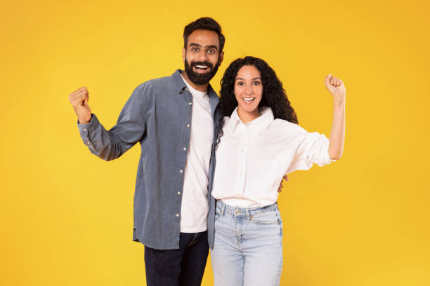 istock Joyful Young Middle Eastern Couple Shaking Fists Over Yellow Background 1777278276