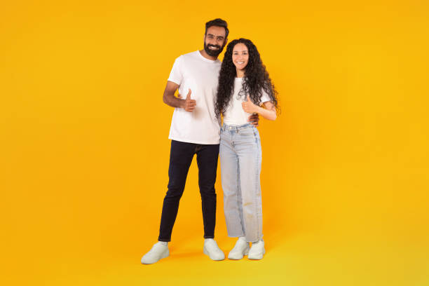 istock Arabic spouses showing thumb ups and embracing over yellow background 1777278512