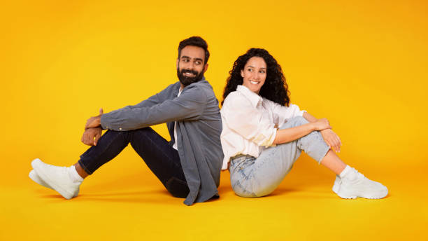 istock Happy middle eastern spouses sitting back to back, yellow background 1777278519