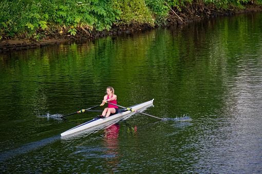 Side view of young adult rowing men practicing