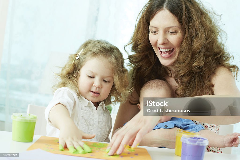 Finger-painting Happy mother and kids doing finger-painting Child Stock Photo