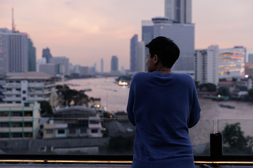 Back view of Asian young LGBT looking to river in Bangkok, Thailand