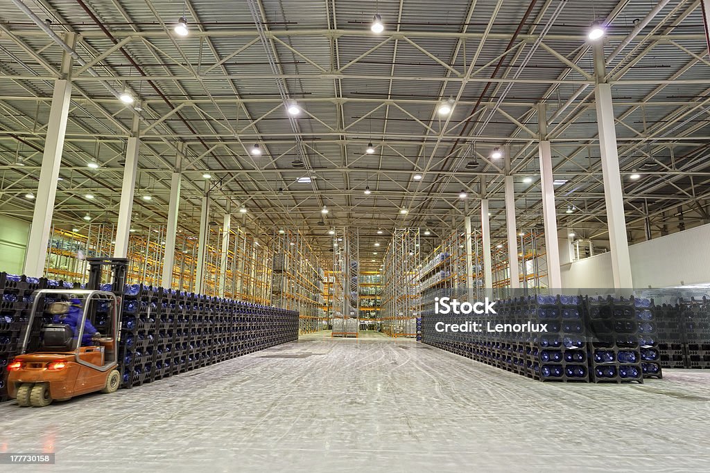 Forklift moving plastic stackable crates in a warehouse Big constitution for storage of finished goods at a factory on manufacture of mineral water Warehouse Stock Photo