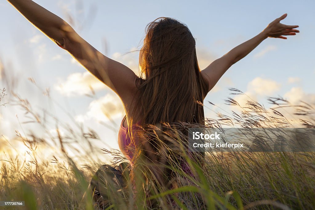 Freedom Young woman with arms to stretched in open field. Arms Raised Stock Photo