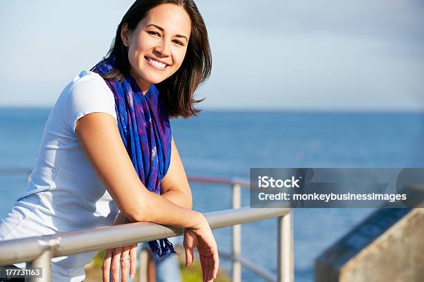 Hispanic Woman Looking Over Railing At Sea Stock Photo - Download Image Now - 30-39 Years, Adult, Adults Only