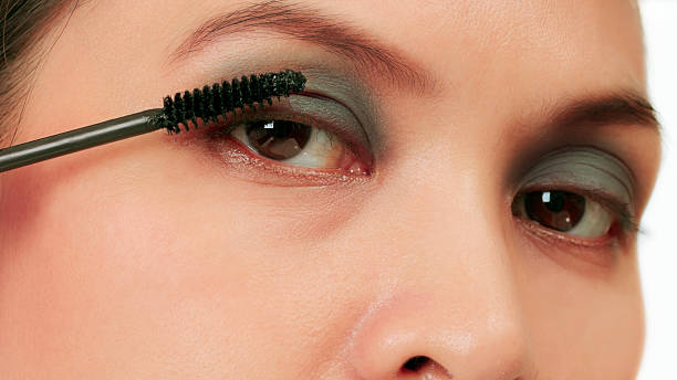 istock Isolated Asian woman applying mascara on white. 177732105