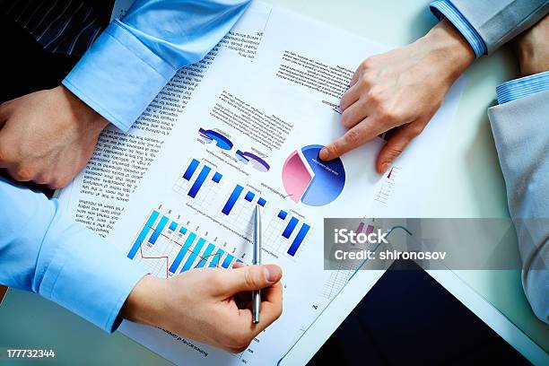 Two Businessmen Discussing A Colorful Info Graph Stock Photo - Download Image Now - Arranging, Business, Business Person