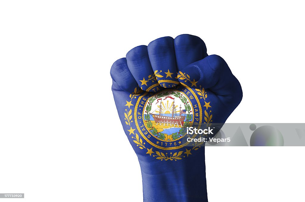 Fist painted in colors of us state new hampshire flag Low key picture of a fist painted in colors of american state flag of new hampshire Aggression Stock Photo