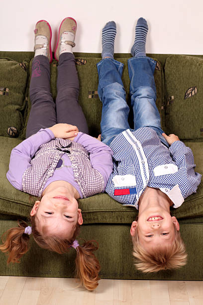 istock little girl and boy lying upside down on the bed 177734259