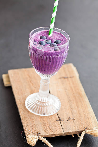 blaubeer-milch-smoothie - blueberry smoothie glass striped stock-fotos und bilder