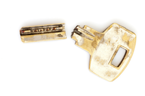 Old broken key isolated on a white background