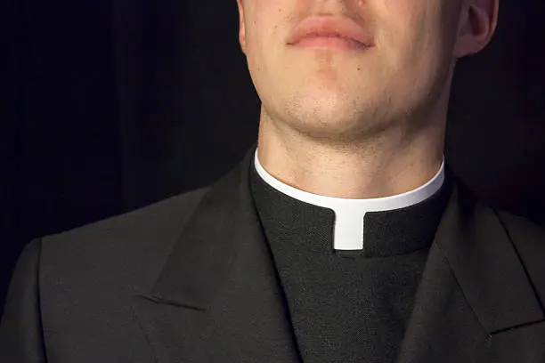 Close-up of Priest collar with black background.