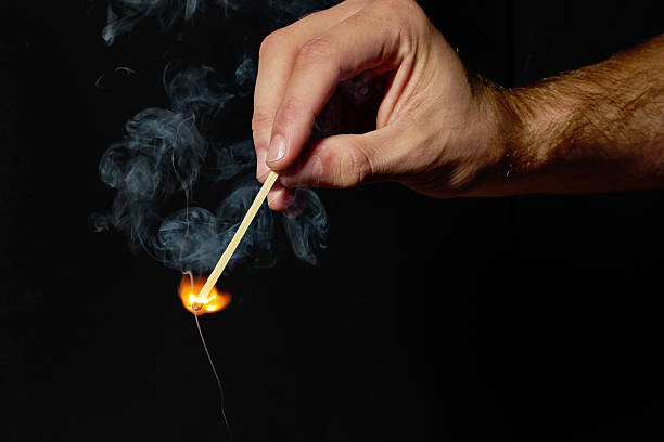 istock Hand holding burning match stick on black background 177737884
