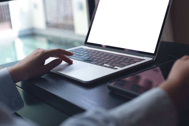istock Mockup blank screen laptop computer, woman using laptop computer with blank screen on wooden table at home 1777401293